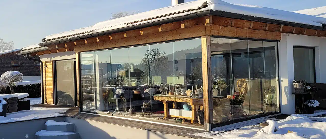 Alternativen zu einem Wintergarten: Maßgeschneiderte Sunflex-Glasschiebetüren schließen überdachte Terrassen wetterfest ab, lassen Licht durch und bieten freie Sicht.