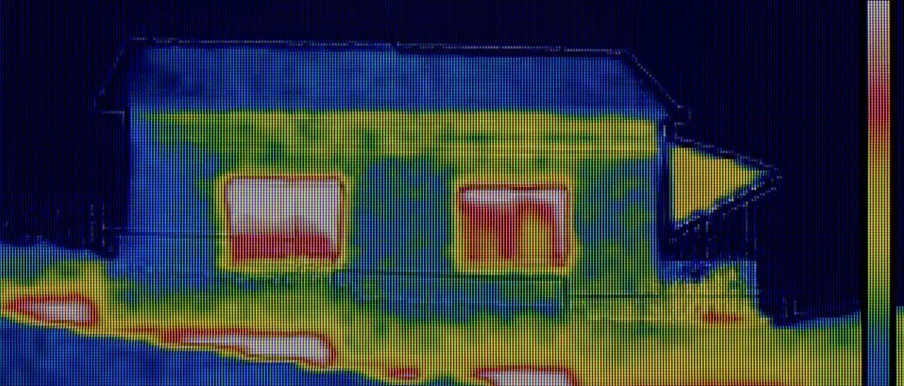 Wärmebild von altem Haus zeigt Wärmeverlust an Fenstern - Rote stellen als Schwachstellen sichtbar.