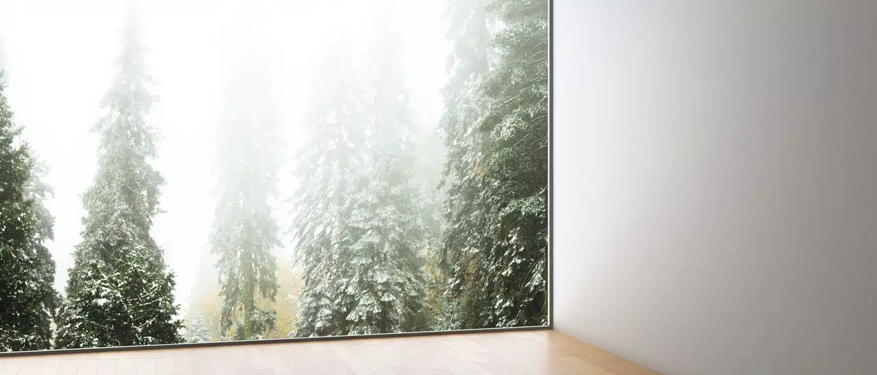 Festverglastes großes Glasfenster mit Blick auf grüne Bäume und Natur.