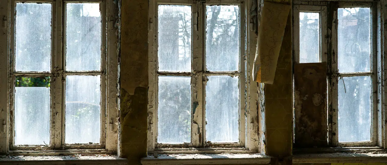 Holzoberflächen von alten Fenstern auf Lack, Verformungen, Fäulnis und Dichtungen prüfen: Wichtige Fenstertausch Kriterien.