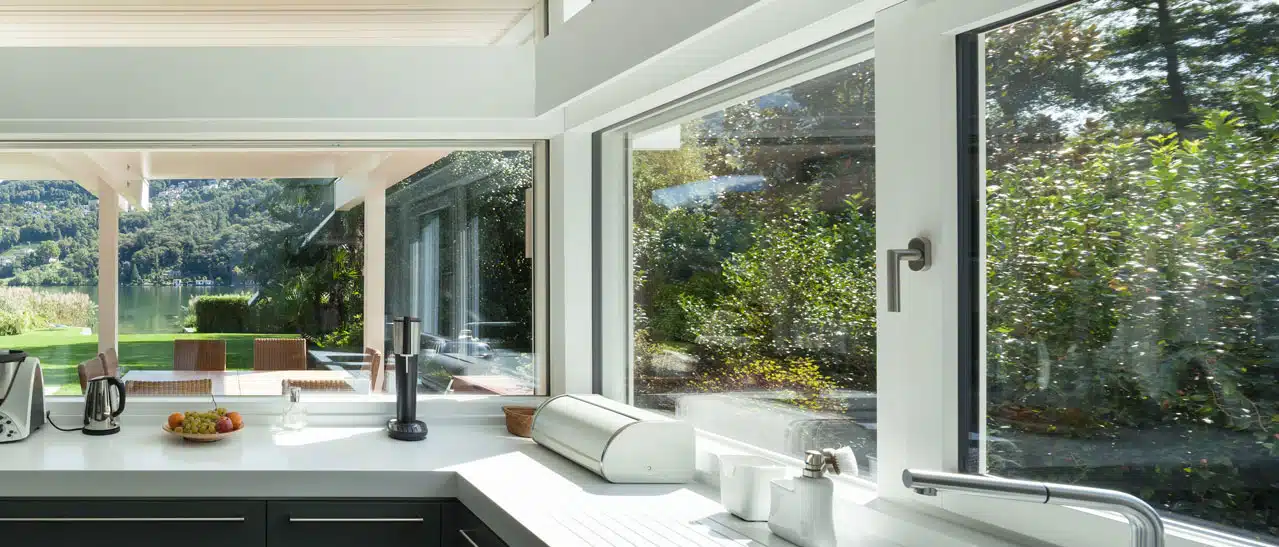 Moderne weiße Dreh-Kipp-Fenster in Küche mit großen Festverglasungen für helle Atmosphäre.