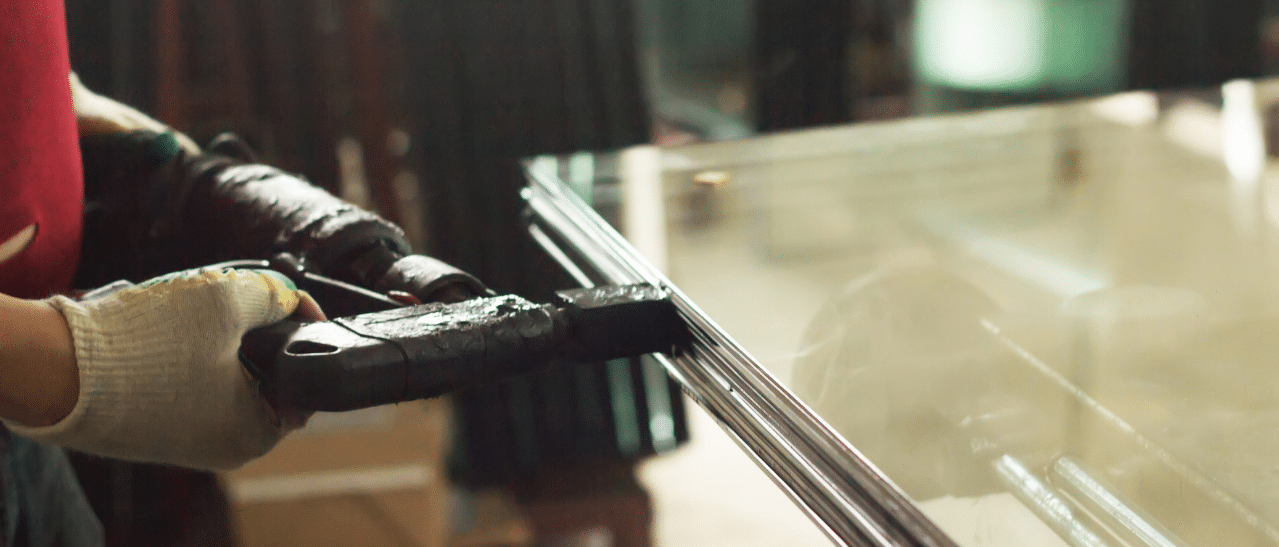 Dieses Foto zeigt, wie ein Isolierglas im Produktionsablauf durch Butyl versiegelt wird.